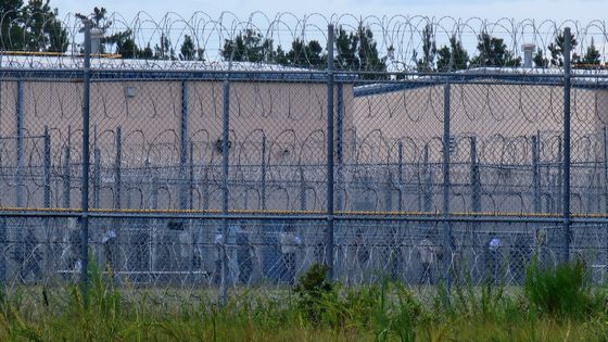 현지시간 6일 미국 조지아주 포크스턴에 위치한 불법 체류자 구금시설에 수감된 한국인 근로자 300여명이 시설내 조사실로 줄을 지어 이동하고 있다. 이들은 푸른색 수용복 하의를 입었고, 손에는 서류(붉은색 원)를 한장씩 들고 있었다. 포크스턴=강태화 특파원