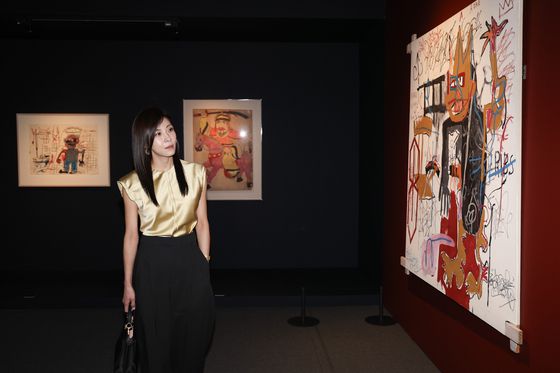 22일 ‘장 미셀 바스키아 : 과거와 미래를 잇는 상징적 기호들’ 특별전 프리뷰에 참석한 배우 하지원이 전시를 관람하고 있다. 가운데 그림은 한국 민화 '최영 장군'. 전민규 기자