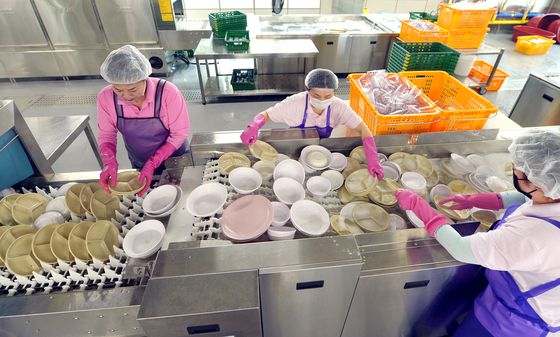 청주시 다회용기 공공세척센터에서 세척팀 직원들이 그릇을 고압 세척기에 넣고 있다. 김성태 객원기자