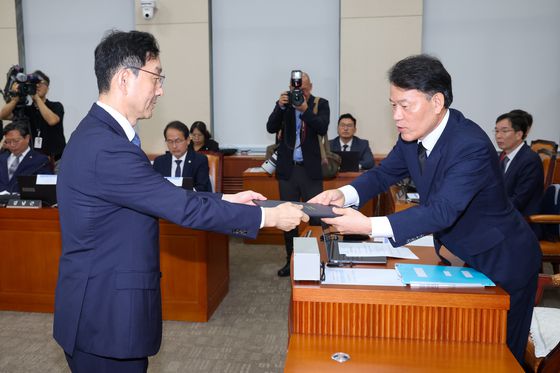 윤창렬 국무조정실장이 13일 서울 여의도 국회에서 열린 정무위원회 국정감사에 출석해 윤한홍 위원장에게 선서문을 전달하고 있다. 뉴스1