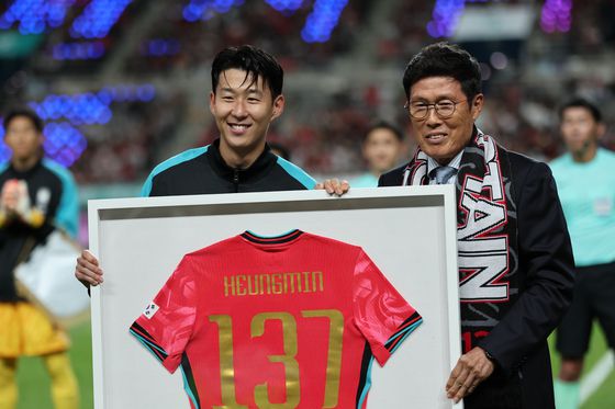한국 남자 선수 A매치 최다 출전한 손흥민이 14일 오후 서울 마포구 서울월드컵경기장에서 열린 하나은행 초청 축구국가대표팀 친선경기 대한민국과 파라과이의 경기 시작 전 차범근 전 감독에게 기념 유니폼을 전달받고 기념촬영을 하고 있다. 최기웅 기자.
