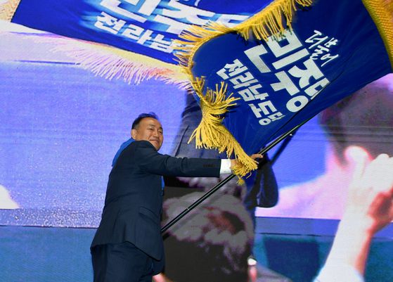 김원이 더불어민주당 신임 전남도당위원장이 2일 전남도당 임시 당원대회에서 당기를 흔들고 있다. 뉴시스