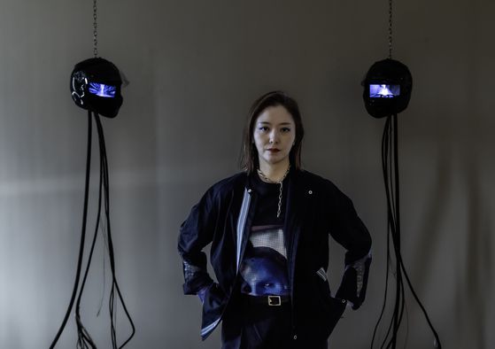 '딜리버리 댄서' 시리즈의 초기작 '고스트 댄서 A'(2022) 사이에 선 김아영. 텅 빈 헬멧 속 태블릿 화면에서 바이크에 올라 거리를 질주하는 인물이 반복재생된다. 권혁재 사진전문기자