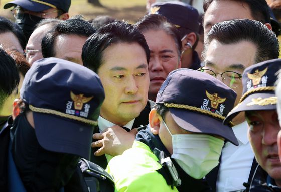 6일 오후 광주 북구 국립5·18민주묘지에서 시민단체 한 회원이 장동혁 국민의힘 대표의 참배를 반대하며 추모 화환을 치우고 있다. 이날 참배 시도 과정에서 장 대표 지지자들과 시민단체 회원들 사이에서 서로 밀치거나 고성이 오가는 등 충돌이 빚어졌다. 뉴스1