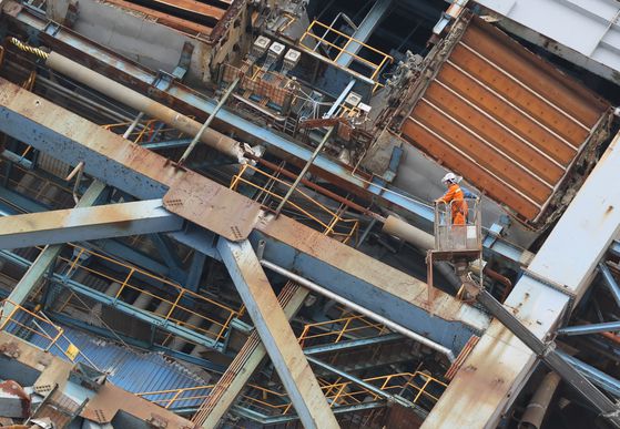 지난 12일 오후 소방재난본부 관계자들이 울산화력발전소 무너진 보일러타워 5호기의 추가붕괴를 막기 위해 대형크레인에 고정하는 작업을 하고 있다. 송봉근 객원기자