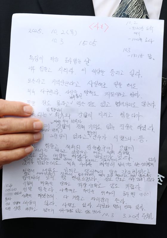 박경호 변호사가 지난달 14일 김건희 특검 사무실이 마련된 서울 종로구 KT광화문빌딩 웨스트 앞에서 사망한 정모(57)씨가 남긴 메모를 공개하고 있다. 뉴시스