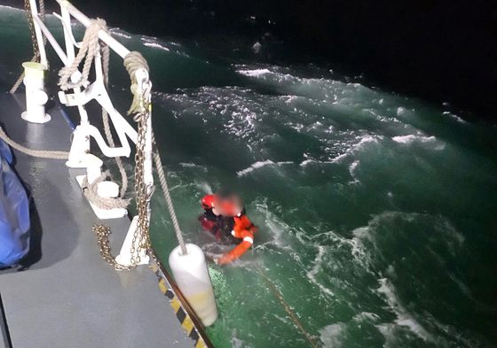 지난 4일 오후6시20분쯤 충남 태안 천리포 해상에서 선원들이 선복된 어선에 올라가 구조를 기다리고 있다. [사진 태안해경]