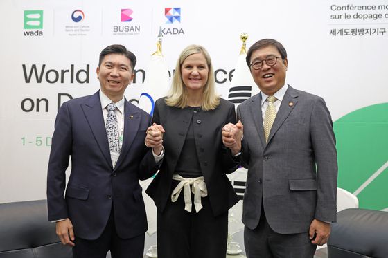 최휘영 문화체육관광부 장관(오른쪽)이 지난 2일 '2025년 제6차 세계도핑방지기구(WADA) 총회'가 열린 부산 해운대구 벡스코에서 커스티 코번트리 IOC 위원장(가운데)과 면담을 마친 뒤 유승민 대한체육회장과 함께 손을 잡고 기념사진을 찍고 있다. 뉴스1