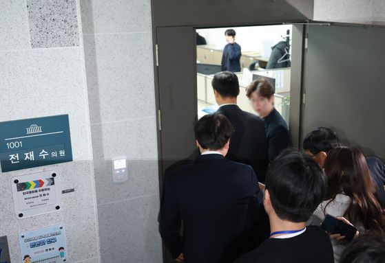 정치권 인사들의 통일교 금품 수수 의혹과 관련해 첫 강제수사에 착수한 15일 경찰 관계자들이 국회 의원회관 내 전재수 전 해양수산부 장관 사무실로 들어가고 있다. 연합뉴스
