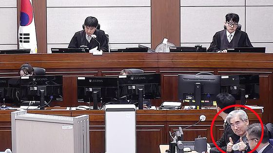 김용현 전 국방부 장관(붉은 원)이 재판을 받는 중에 방청석을 향해 엄지손가락을 올려보이고 있다. 사진 유튜브 캡처