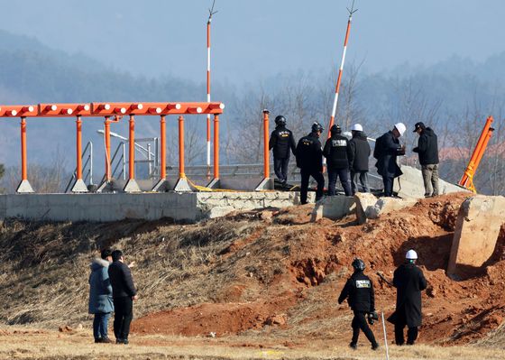 전남 무안국제공항에서 항공철도사고조사위원회, 경찰, 국과수 관계자들과 제주항공 참사 유가족 대표단이 방위각 시설(로컬라이저)을 살펴보고 있다. 연합뉴스