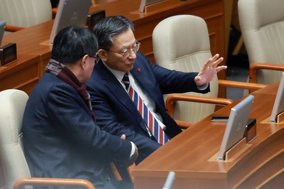 정성호 법무부 장관이 23일 국회에서 열린 12월 임시국회 본회의에서 국민의힘 이헌승 의원과 대화하고 있다. 연합뉴스