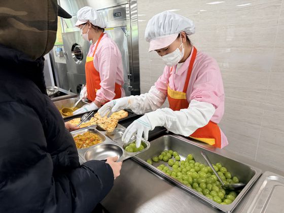 지난 1일 오후 제주시 제주여자상업고등학교 급식종사자가 급식실 조리공간에서 인공지능(AI) 기반 제주형 학교급식 조리로봇을 활용해 새우튀김을 하고 있다. 최충일 기자