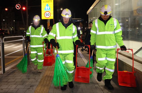 김민석 국무총리(가운데)가 26일 서울 관악구 신림로 일원에서 환경공무관들과 가로 청소를 하고 있다. 연합뉴스