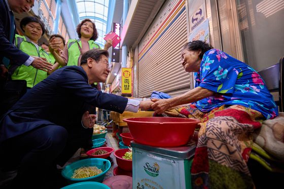 이재명 대통령이 지난 9월 5일 인천 미추홀구 용현시장을 방문해 한 상인이 건네는 음식을 맛보고 있다. 사진 대통령실