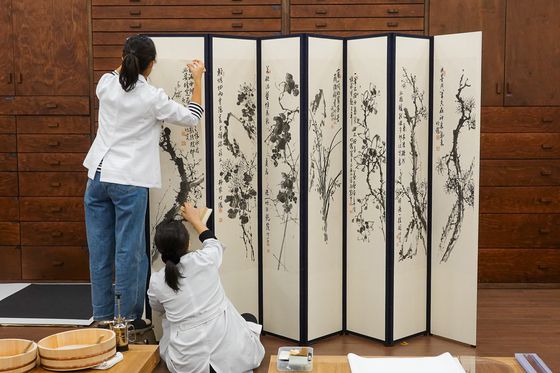 대구간송미술관 수리복원 전문 학예사들이 서동균 군자화목(대구미술관 소장)의 수리복원 과정을 진행하고 있다. 사진 대구간송미술관