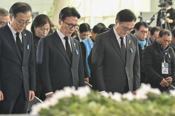 제주항공 여객기 참사 1주기인 29일 오후 전남 무안국제공항 활주로에서 참사 유가족들이 모여 여객기가 충돌한 콘크리트 둔덕(로컬라이저)의 잔해를 바라보고 있다. 뉴시스
