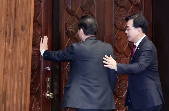 김병기 전 더불어민주당 원내대표가 30일 오후 송언석 국민의힘 원내대표와 대화하면서 본회의장을 나가고 있다. 김성룡 기자