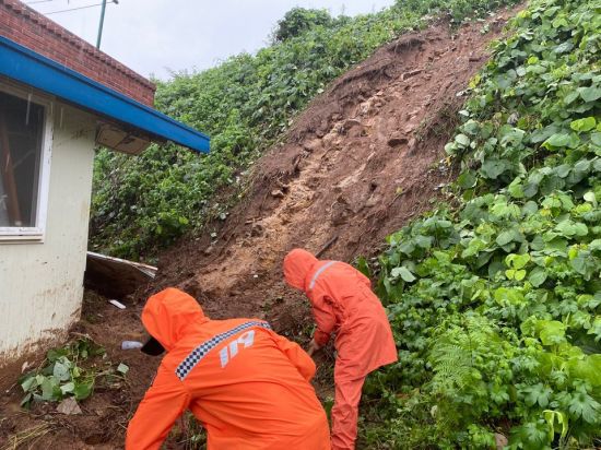 29일 오전 8시 18분께 장성군 삼계면 내계리 한 주택 뒤 경사지에서 토사가 무너져 내려 소방대원들이 복구 작업을 펼치고 있다. 사진=전남소방본부 제공