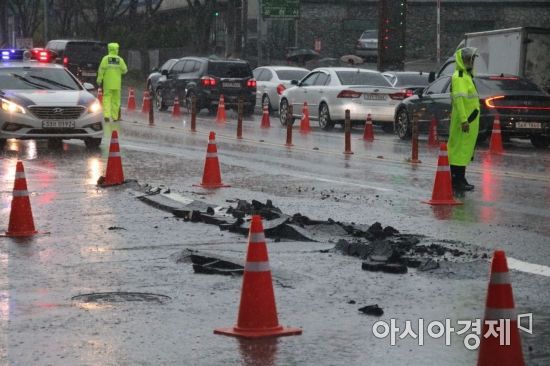 광주지역에 호우특보가 발효된 7일 오후 2시께 광주광역시 서구 상무중학교 앞 도로 일부가 파손돼 교통이 통제되고 있다. 당시 서구 일대에는 시간당 50㎜의 비가 내렸다.