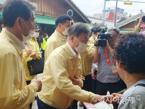 문재인 대통령이 12일 전남 구례군 구례읍 봉동리 5일 시장을 찾아 손을 잡아주며 상인을 위로하고 있다.