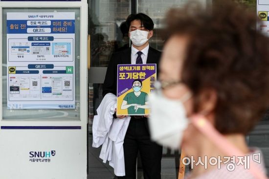 인턴, 레지던트 등 종합병원에서 수련하는 전공의들이 정부가 추진하는 의과대학 정원 확대 정책등에 반대해 파업에 들어간 21일 서울 종로구 서울대학교병원 본관 앞에서 한 전공의가 일인시위를 하고 있다./강진형 기자aymsdream@