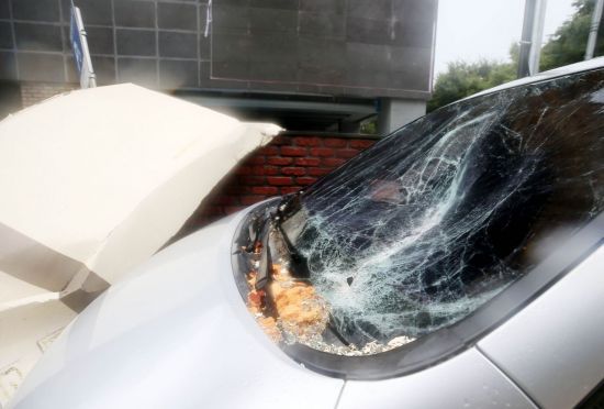 제8호 태풍 '바비'가 제주를 강타한 26일 오후 제주시 동광로 한 아파트 외벽 마감재가 떨어져 주차된 차량을 덮치고 있다. [이미지출처=연합뉴스]