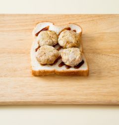 2. 식빵 1장에 스테이크 소스를 골고루 바르고 동그랑땡을 얹는다.(Tip.동그랑땡은 냉동된 상태라면 전자렌지에 해동하거나 살짝 데워서 활용한다.)