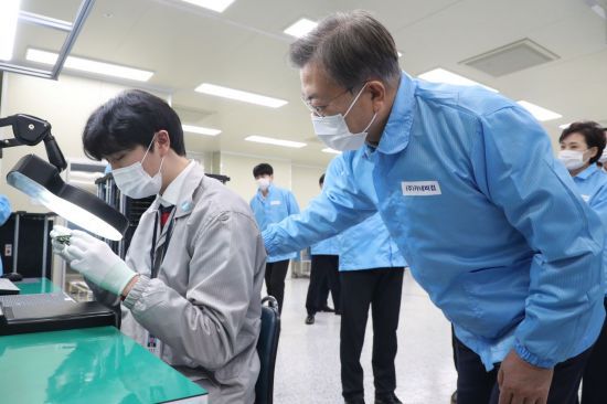 문재인 대통령이 22일 오후 디지털 SOC기업인 인천시 연수구 카네비컴을 방문해 불량품 검사하는 직원을 격려하고 있다.