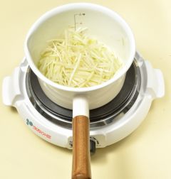 2. 냄비에 참기름을 두르고 무를 넣어 볶다가 3분 지나면 뚜껑을 덮어 3분 정도 더 익힌다.