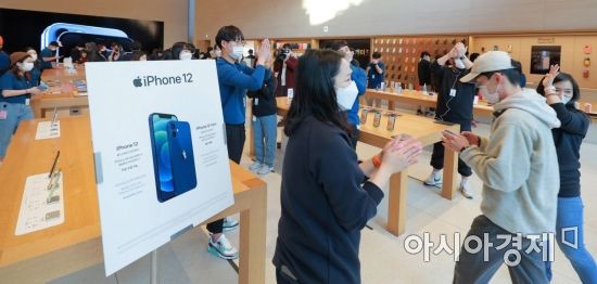 애플의 첫 5G 스마트폰 아이폰12 시리즈가 국내 공식 출시한 30일 서울 강남구 가로수길 애플스토어에서 고객들이 직원들의 축하를 받으며 입장하고 있다./김현민 기자 kimhyun81@