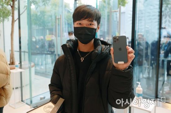 애플의 첫 5G 스마트폰 아이폰12 시리즈가 국내 공식 출시한 30일 서울 강남구 가로수길 애플스토어에서 구매 고객이 제품을 들어보이고 있다./김현민 기자 kimhyun81@