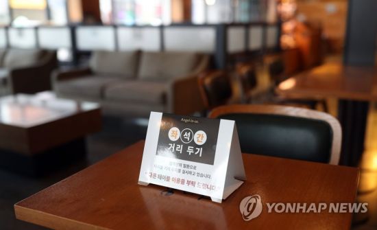 사회적 거리 두기 2단계가 시행중인 22일 경남 하동군 하동읍 한 커피숍에 '사회적 거리 두기'가 적힌 팻말이 놓여 있다. [이미지출처=연합뉴스]