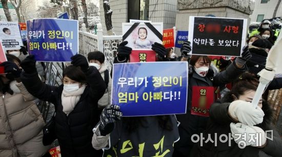 16개월 된 입양 딸 정인양을 학대해 숨지게 한 혐의를 받고 있는 양부모에 대한 첫 공판이 열린 13일 서울 양천구 남부지방법원 앞에서 시민들이 살인죄 적용을 촉구하며 시위하고 있다./김현민 기자 kimhyun81@