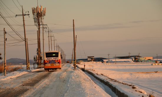 눈덮인 시골길을 달리는 마을버스
