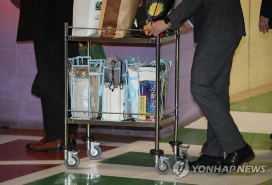 코로나19 확진자 밀접 접촉자로 분류된 뒤 병원에서 격리를 마치고 머물던 박근혜 전 대통령이 9일 오후 서울 서초구 서울성모병원 퇴원했다. 관계자들이 박 전 대통령의 소지품을 옮기고 있다. 방역용 마스크와 영어, 스페인어 사전이 눈에 띈다. [이미지출처=연합뉴스]