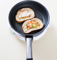 3. 팬에 올리브오일을 두르고 곡물빵을 얹는다. 볶은 채소와 달걀물을 넣고 오려 놓은 빵을 얹는다.