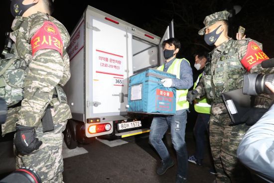 제주도민에게 접종할 코로나19 백신 3900회분을 실은 1t 냉동탑차가 25일 오전 제주시보건소에 도착해 관계자가 백신을 담은 상자를 보건소 내부로 옮기고 있다. [이미지출처=연합뉴스]