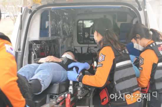 19일 오전 모의훈련이 실시된 광주 1호 코로나19 지역예방접종센터에서 접종 대상자가 접종 직후 이상반응을 보여 구급차로 이송되고 있다.