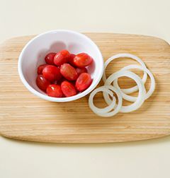2. 방울토마토는 십자로 칼집을 내어 끓는 물에 잠깐 넣었다 건져 껍질을 벗긴다. 양파는 얇게 채 썬다.
