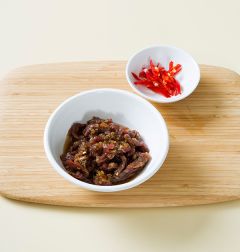 3. 쇠고기는 채 썰어 분량의 양념 재료에 버무린다. 홍고추는 반으로 갈라 어슷하게 썬다.