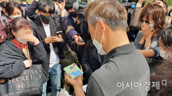 정민씨의 아버지 손현씨가 한 시민에게 정민씨 사진을 그린 그림을 받고 있다./사진=이정윤 기자 leejuyoo@