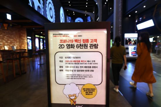 2일 용산 CGV 입구에 코로나19 백신 접종 고객을 대상으로 영화 관람료를 할인해주는 캠페인 안내문이 붙어 있다. [이미지출처=연합뉴스]