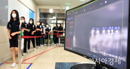 수도권 중학교의 등교 수업이 확대된 14일 오전 서울 양천구 월촌중학교에서 등교한 학생들이 발열 검사 및 손 소독 등 코로나19 방역 절차를 거친 뒤 교실로 향하고 있다. 교육부는 누적된 수업 부족으로 인한 학력 격차 문제를 해소하기 위해 이날부터 수도권 중학교의 학교 밀집도 기준을 전체 3분의 1에서 3분의 2로 완화했다. 2021.6.14 사진공동취재단