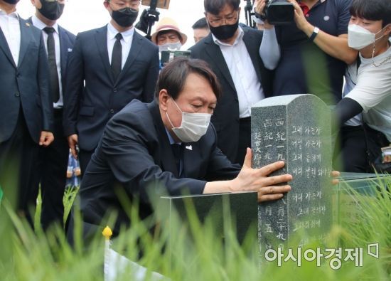 야권 대선주자인 윤석열 전 검찰총장이 광주 운정동 민족민주열사묘역(옛 망월묘역)에서 이한열 열사 묘비를 어루만지고 있다.