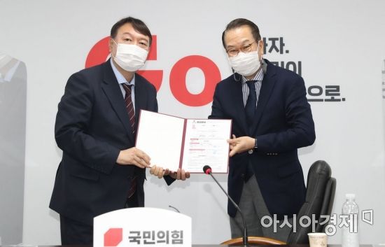 대선 출마를 선언한 윤석열 전 검찰총장이 30일 서울 여의도 국민의힘 중앙당 당사를 방문, 권영세 대외협력위원장에게 입당원서를  제출하고 있다./국회사진기자단