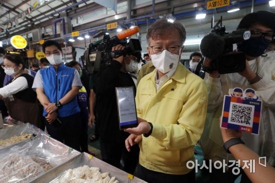 권칠승 중소벤처기업부 장관이 서울 서대문구 영천시장에서 온누리상품권 제로페이로 강정을 구매한 뒤 취재진에게 휴대전화를 들어보이고 있다. /문호남 기자 munonam@