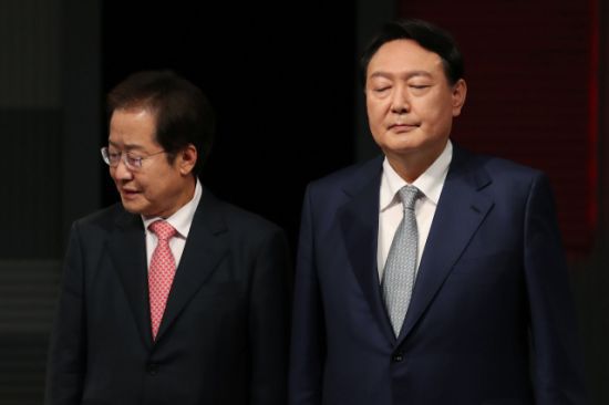 국민의힘 대선 경선 후보인 홍준표 의원(왼쪽)과 윤석열 전 검찰총장이 지난 15일 저녁 서울 마포구 상암동 MBC 사옥에서 열린 '1대1 맞수토론'에 앞서 기념사진을 찍은 뒤 자리로 향하고 있다. /사진=연합뉴스
