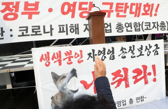 지난 16일 오후 경남 창원시 성산구 경남도청광장 교차로 앞 도로에서 열린 '코로나19 피해 실질 보상 촉구  정부·여당 규탄대회'에서 참가자들이 동전을 던지며 손실보상금을 비판하고 있다. / 사진=연합뉴스