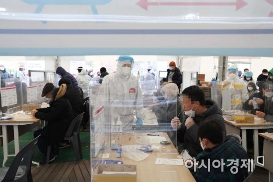 코로나19 신규 확진자가 사상 처음으로 10만 명을 넘어선 18일 서울 송파구보건소 선별진료소에서 시민들이 신속항원검사를 하고 있다. /문호남 기자 munonam@